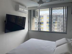 里考尔特Hermoso conjunto residencial con piscina!的一间卧室设有一张床、一台电视和一个窗口。