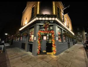 伦敦Dockers Inn的前方有圣诞树的建筑