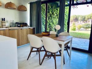 圣卢西亚岛Beach House Pedras D'el Rei的厨房配有木桌和白色椅子