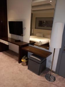 利雅德Taleen Hotel的一间卧室配有一张桌子、一台电脑和一张床