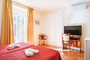 赫雷斯-德拉弗龙特拉Hotel Carlos V Jerez by Vivere Stays的一间卧室配有两张床、一张桌子和一台电视。