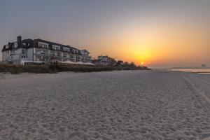 蒂门多弗施特兰德Mein Strandhaus - Hotel, Restaurant & Schwimmbad的日落时分海滩美景