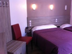 巴黎格兰德酒店的酒店客房,设有两张床和一张红色椅子