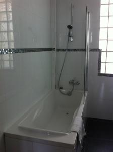 巴黎格兰德酒店的浴室设有带淋浴的白色浴缸。