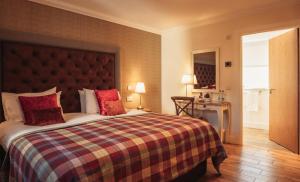 BowmoreThe Bowmore Lodge的一间卧室配有一张带红色枕头的大床