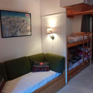 贝勒沃Appartement dernier étage au pied des pistes HIRMENTAZ的客房设有绿色沙发和双层床。