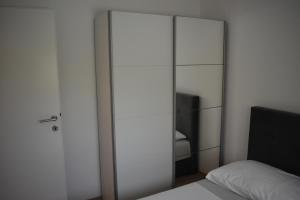 扎达尔Apartman DODO的卧室配有玻璃衣柜和床