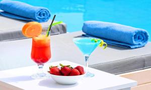 伊罗达Elounda Garden Suites Heated Pool的一张桌子,上面放着两杯鸡尾酒和一碗草莓