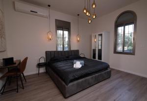 海法King's bed - Stay Royal and Stylish Bahai's Garden的卧室配有一张床和一张桌子及椅子