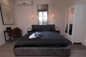 海法King's bed - Stay Royal and Stylish Bahai's Garden的一间卧室配有一张床,床上有毛巾