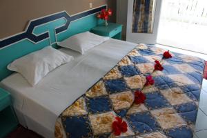 哈马马特艾米拉酒店的一张大床,上面有红色的鲜花