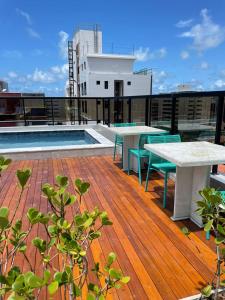 若昂佩索阿Hotel do Mar Tambaú的大楼内带桌子和游泳池的屋顶甲板