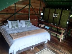 萨兰托Ecohotel Pinohermoso Reserva Natural的一间卧室配有一张床,铺有木地板