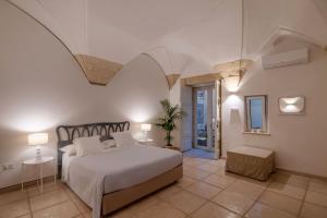 莱切B&B Corte Dei Romiti - Suites & Apartments SIT的一间带大床的卧室和一间带天花板的房间