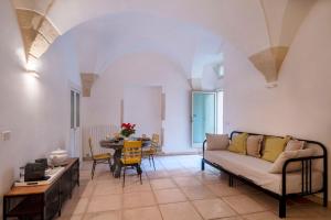 莱切B&B Corte Dei Romiti - Suites & Apartments SIT的客厅配有沙发和桌子