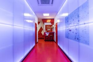 马德里Art Seven Hostel Capsules的红色地板和红色走廊的走廊
