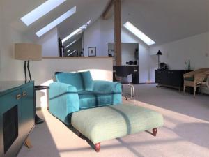 LindoresWoodmill Arches - Designer Barn Conversion for Two的客厅配有蓝色椅子和搁脚凳