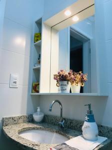 乌巴图巴Apt Familiar-Condomínio fechado UBATUBA的浴室的柜台设有水槽和镜子