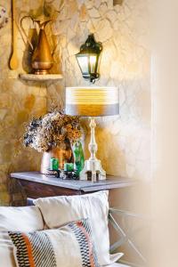 奥比多斯Quinta Da Torre - Óbidos Country House的一张桌子,上面有台灯和花瓶