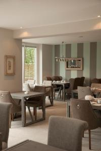 里斯特国王港海滨大道酒店的一间带桌椅的用餐室和窗户。