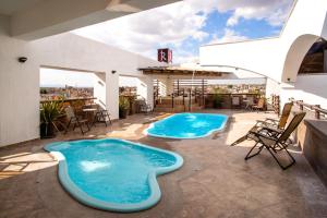 多洛雷斯-伊达尔戈Hotel El Relicario的一座带两个热水浴缸的庭院,位于一座建筑的顶部