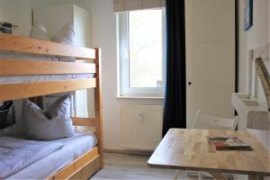 KirchdorfBrandt的一间卧室配有一张双层床、一张桌子和一个窗户。