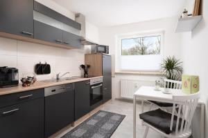 萨尔斯塔特Aparte - Washer & Dryer - Kitchen & Parking - Smart-TV的厨房配有黑色橱柜和白色桌子