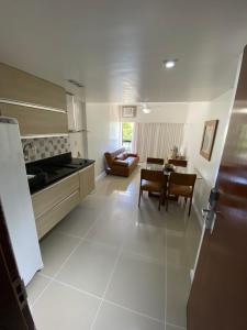 萨尔瓦多Apart Hotel em Ondina的厨房以及带桌椅的起居室。