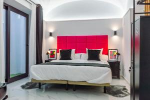 梅里达Apartamentos Élite - Art Collection - Andy的一间卧室配有一张大床和红色床头板