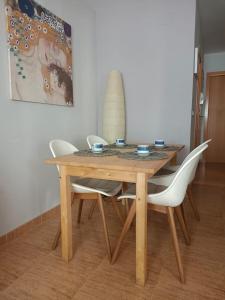 莱斯卡瑟斯-达尔卡纳Les Palmeres Centre的一张木桌,四周摆放着四把白色椅子