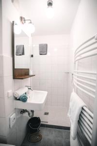 博尔库姆Pension Mai-Scholle的白色的浴室设有水槽和镜子