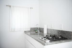 阿瓦隆荷摩沙酒店的白色的厨房配有炉灶和水槽