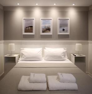 马德普拉塔Posada Güemes BOUTIQUE的一间卧室配有一张带两个白色枕头的大床