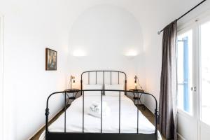 阿克罗蒂里Arcana Santorini Villas, An Authentic Cycladic Experience的一间带金属床和窗户的卧室