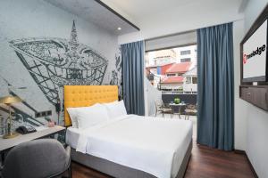吉隆坡Travelodge Chinatown Kuala Lumpur的一间卧室配有一张床、一张书桌和一个窗户。