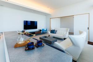 Uki天草三角シーサイドヴィラ的客厅配有白色沙发和电视