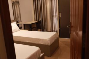 科钦Grace Apart Hotel @Kochi的酒店客房配有两张床和一张书桌