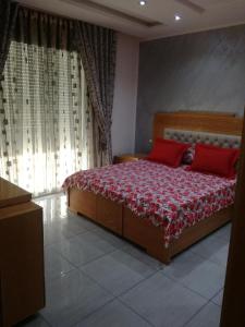古莱比耶s 2 1 km from the beach mansoura kelibia的一间卧室配有一张带两个红色枕头的床