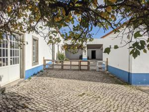 塞辛布拉Pátio Sant'Ana - 2 bedrooms villa w/ exterior area的白色的房子,有蓝色的墙壁和车道
