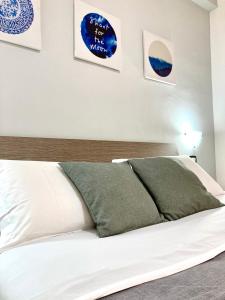 庞贝POMPEI FELIX的卧室配有白色床和2个绿色枕头