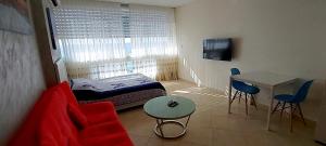 巴特亚姆Sweet Honeymoon Apartment Tel Aviv Bat Yam 611的小房间设有红色的沙发和桌子