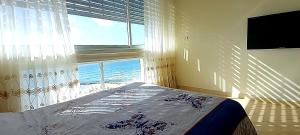 巴特亚姆Sweet Honeymoon Apartment Tel Aviv Bat Yam 611的一间卧室设有一张床和一个大窗户