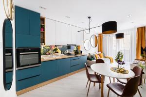 杰尔TELEKI40 Apartman Győr CENTRAL, FREE PARKING, TERRACE的厨房配有蓝色橱柜和桌椅