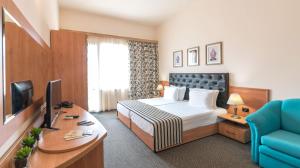阳光海滩Lotus Family Hotel - Free Parking的配有一张床和一张书桌的酒店客房
