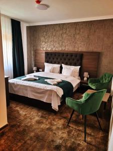 布什泰尼玛格丽塔酒店的一间卧室配有一张大床和一张绿色椅子