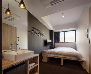 京都三条Piece旅舍的一间卧室配有一张床和一个水槽和一个浴缸