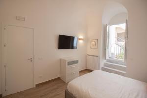 巴勒莫Aragona15 Suites的一间卧室配有一张床,墙上配有电视