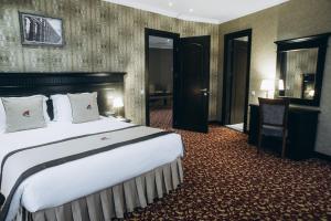 巴统斗兽场码头酒店的酒店客房设有一张大床和一张书桌。