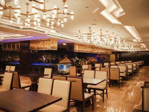 铜仁铜仁九宜城温德姆至尊酒店的餐厅设有桌椅和吊灯。