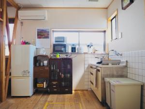 静冈Backpackers Hostel TSUBAMENOYADO的厨房配有冰箱和水槽